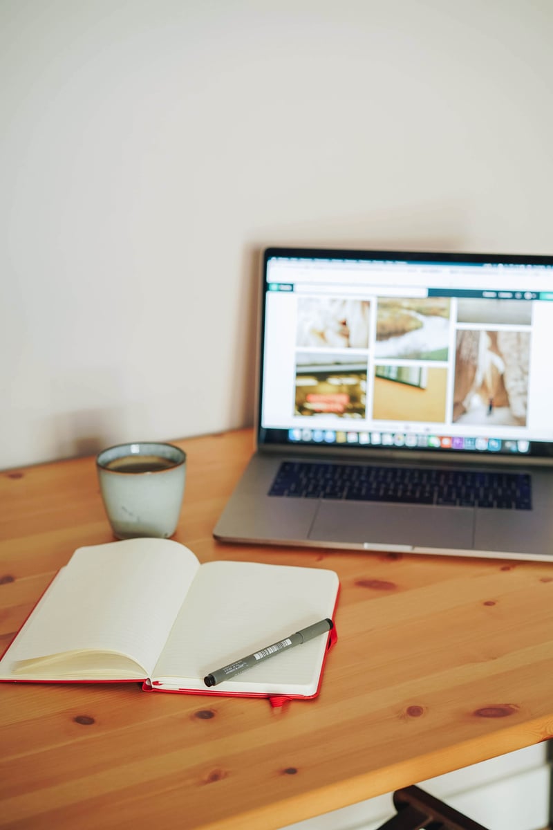 Laptop and Notebook on Wooden Desk